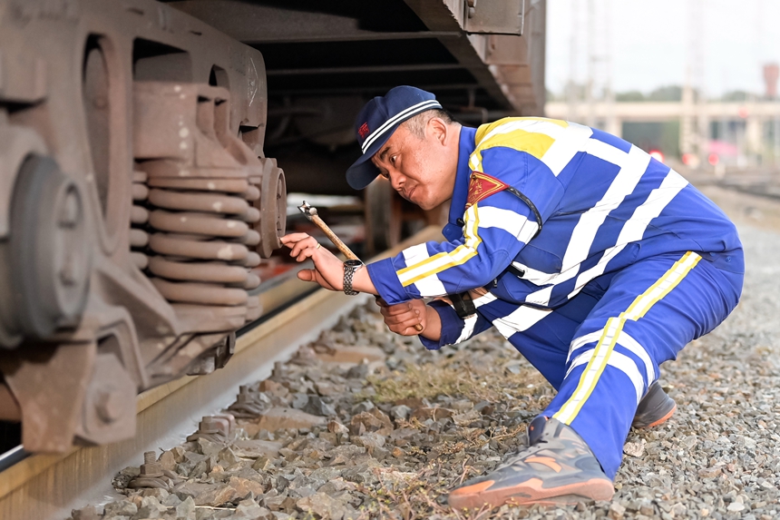 哈爾濱車輛段哈南下行運用車間五場二班四組檢車員正在對車輛走行部進行檢修作業。