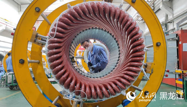 哈電集團佳電股份電工車間職工正在將定子槽楔嵌入鐵心內。????人民網 尚城攝