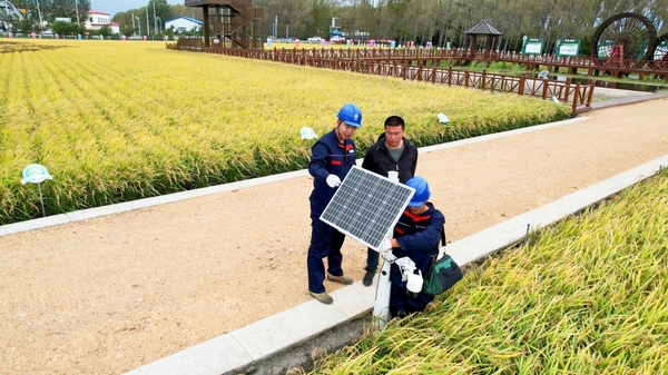 國網建三江供電公司員工深入田間幫助農戶檢修維護田間傳感器。苑小旭攝