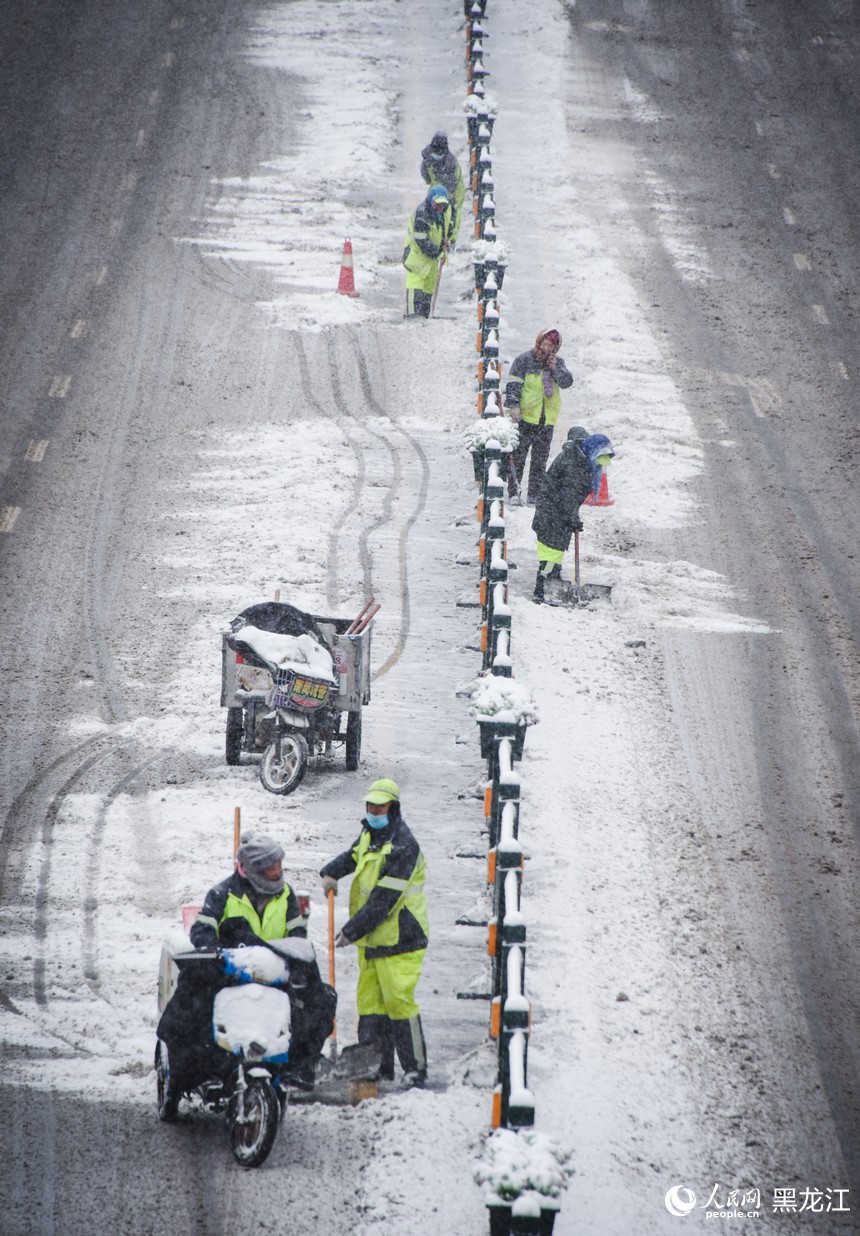 環衛工人正在清理道路積雪，保障路面暢通。人民網記者 蘇靖剛攝