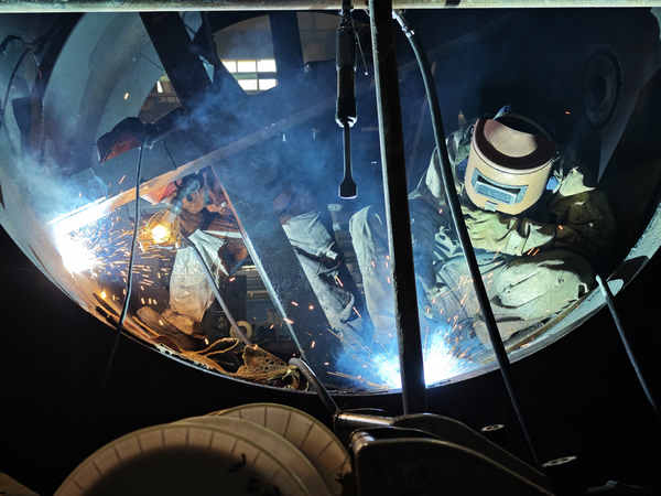 哈電電機焊工正在焊接水電機組伸縮節。王學善攝