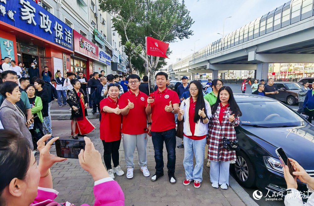 哈爾濱市虹橋第二小學考場外，考生與老師、家長們記錄難忘一刻。人民網記者 張哲鑫攝