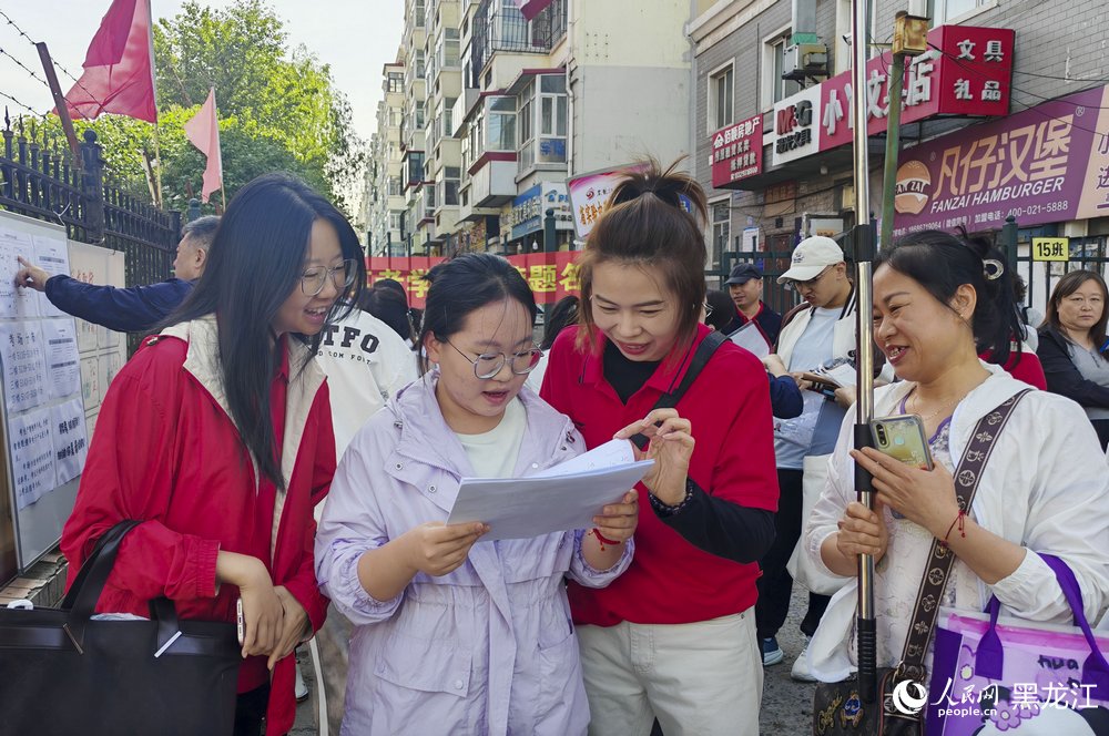 哈爾濱市虹橋第二小學(xué)考場外，考生與老師們洋溢燦爛笑容迎接考試。人民網(wǎng)記者 張哲鑫攝
